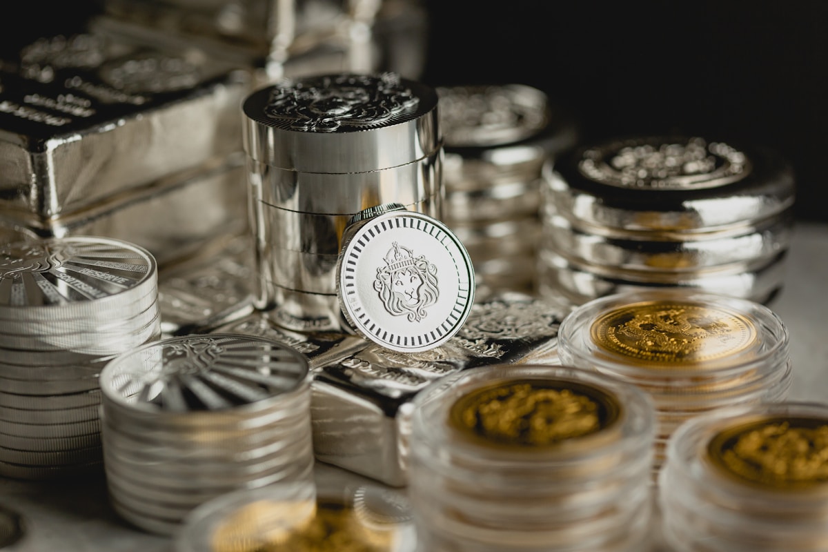 Gold and silver coins and bullion bars spread on a table